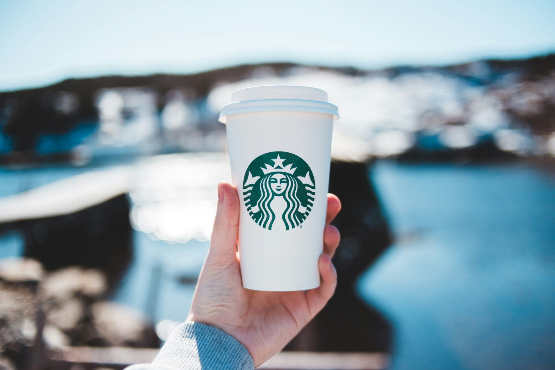 海辺でスターバックスラテを持っている